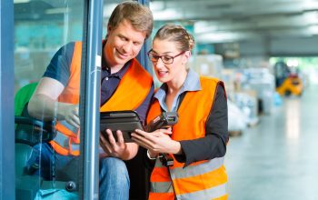 Forklift driver and supervisor at warehouse Logistics Teamwork - forklift driver, Worker or warehouseman and his coworker with scanner at warehouse of freight forwarding company